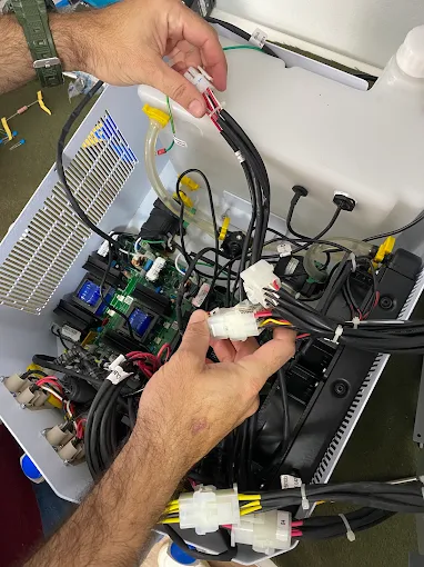Técnico revisando cabeamento e placas de um equipamento